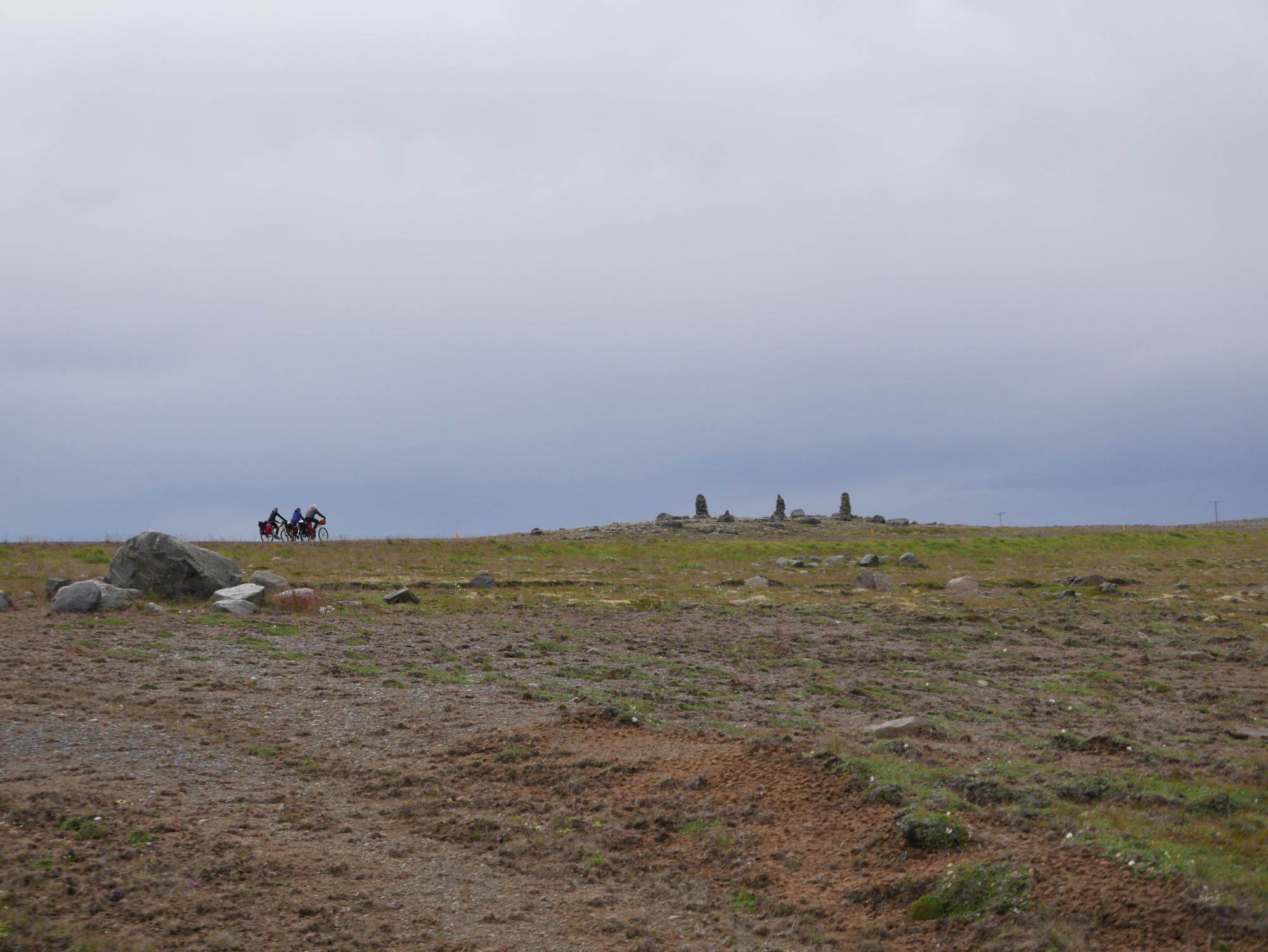 Cyclists riding past standing stones in Iceland