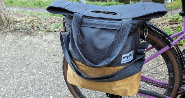 A grey and gold pannier is attached to a rear rack