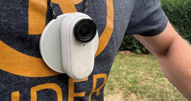 A white cycling camera worn around the neck