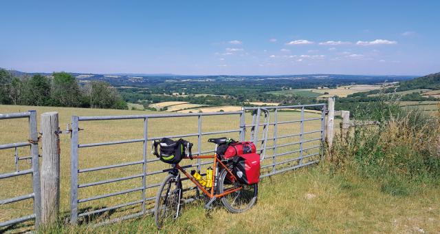 Bike leaning up against a metal fence next to a field on the South Downs Way