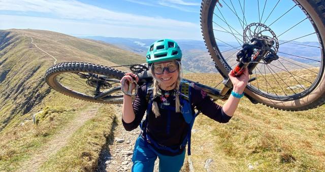 Kate O'Callaghan walking up a hill while holding her bike .jpg