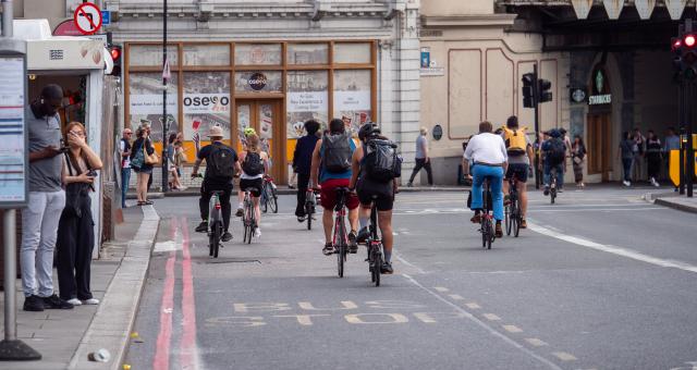 Cyclists coming off London Bridge approaching a red light