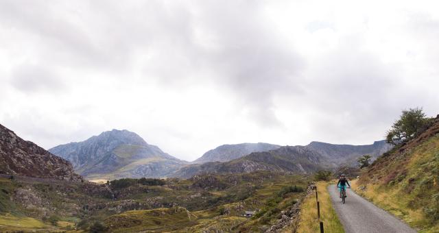 A Cyclist riding along a gravel trail in the Welsh mountains