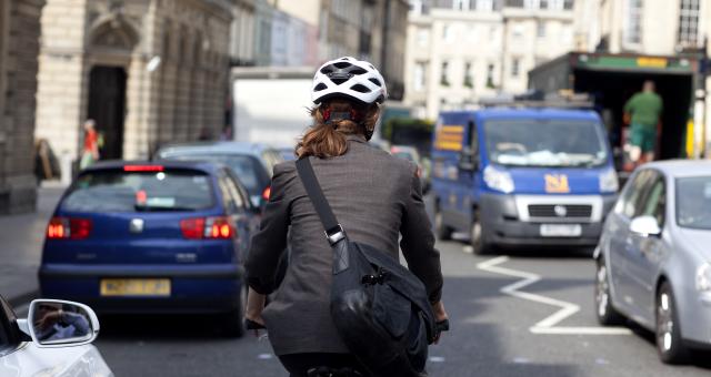 Woman wearing a suit cycling through a city