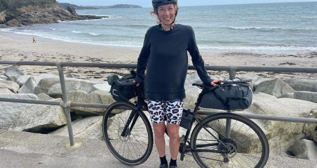 Katy Rodgers stood with bike in front of the sea