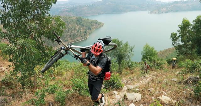 William Tucker carries his bike over rough terrain