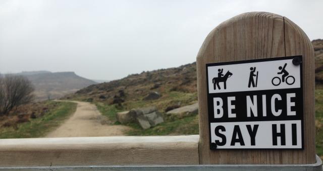 Be Nice Say Hi sign on fence post