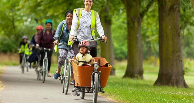 Sarah riding a cargo bike with child in the front