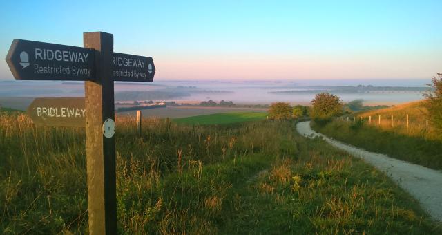 Finger post on the Ridgeway National Trail with hills in distance