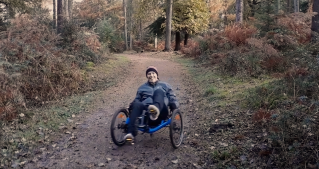 Rider on a trike in the forest.  