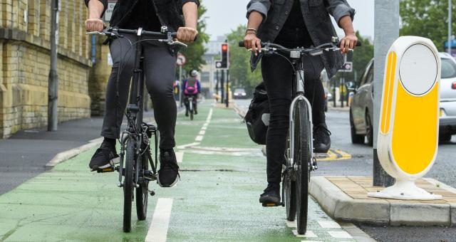 Two people cycling along a cycle lane 