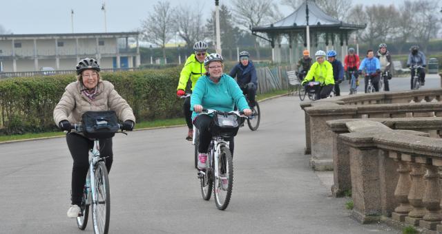 a varied group of people cycling together