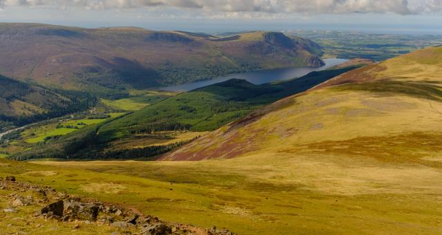 A view of rolling hills and a lake in a distance