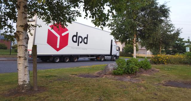 A large lorry in on a small, local road