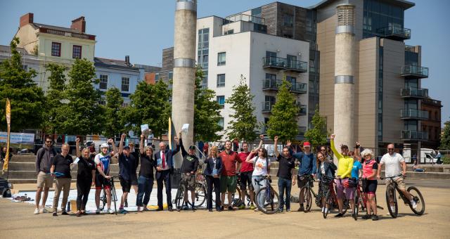 A big group of people standing in the Roald Dahl Plaza, along with assorted bikes