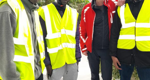 A group of four men in hi-viz jackets