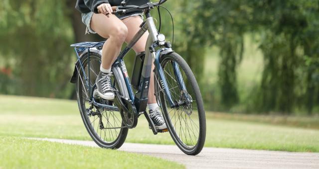 Woman riding an ebike on a path