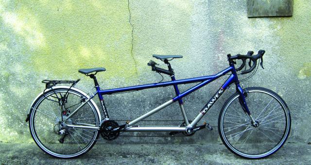 Dawes Galaxy Twin, a blue and silver tandem bike leaning against a concrete wall with a crack in it