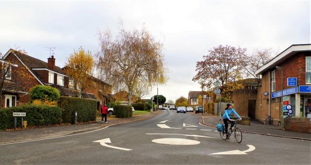 A woman cycling around a roundabout. 